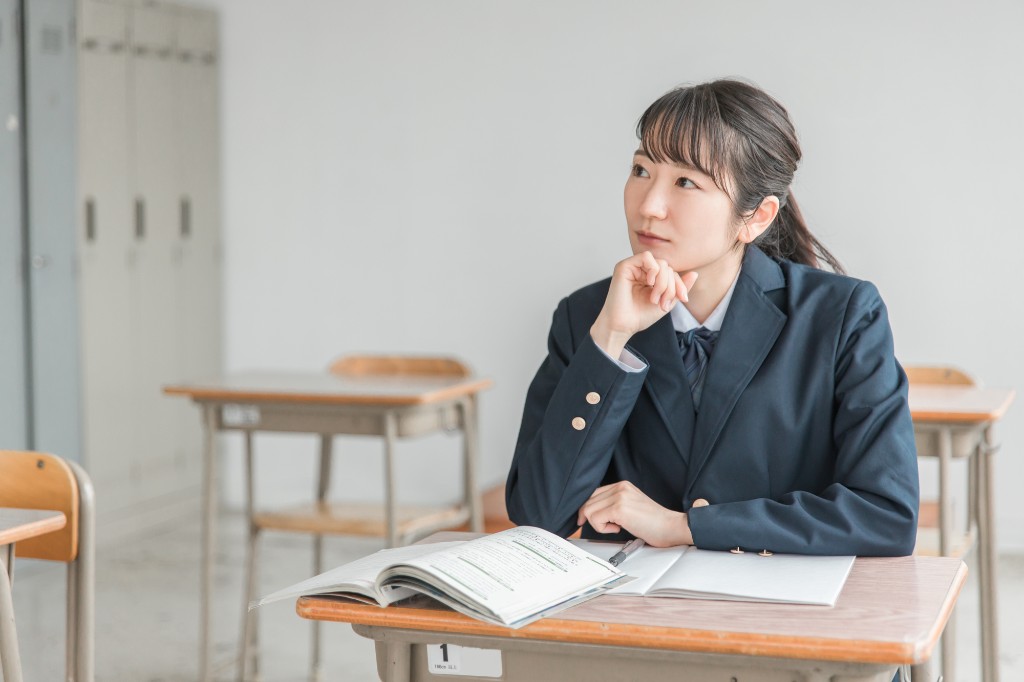 教室で教科書を開き、2級対策を考える高校生