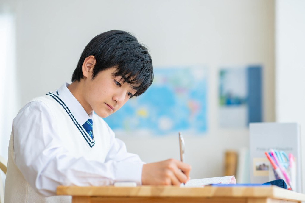 机でノートに書きながら2級の学習をする生徒