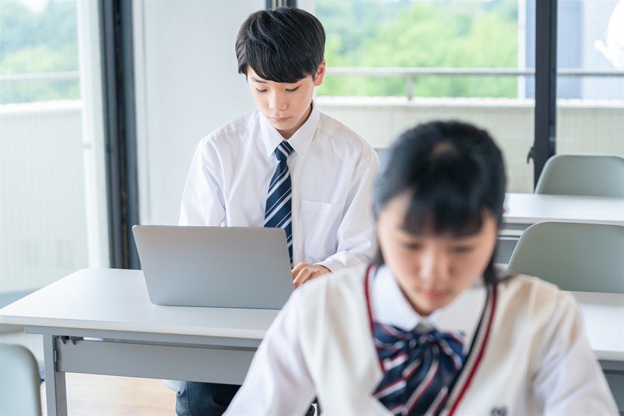 ノートPCで学習する制服の生徒