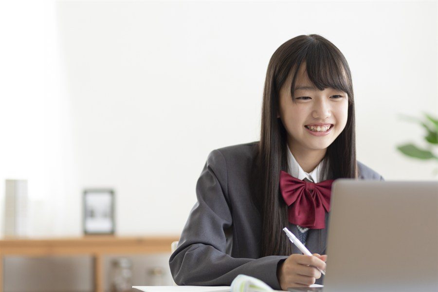 ノートPCを見ながら学習する制服の生徒