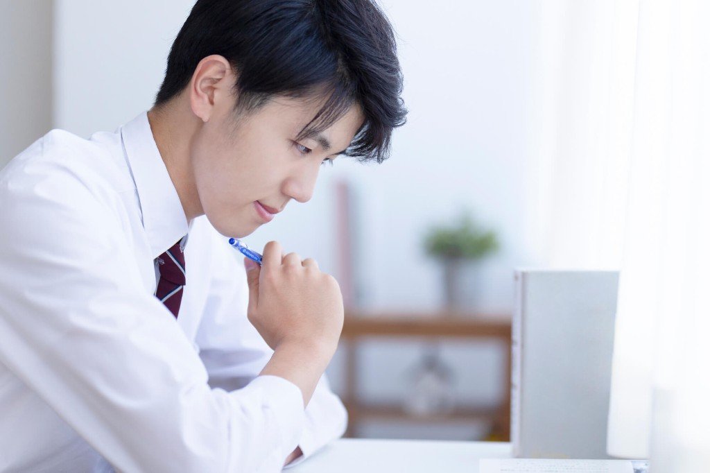 ペンを手に、画面を見ながら準1級の学習を考える学生