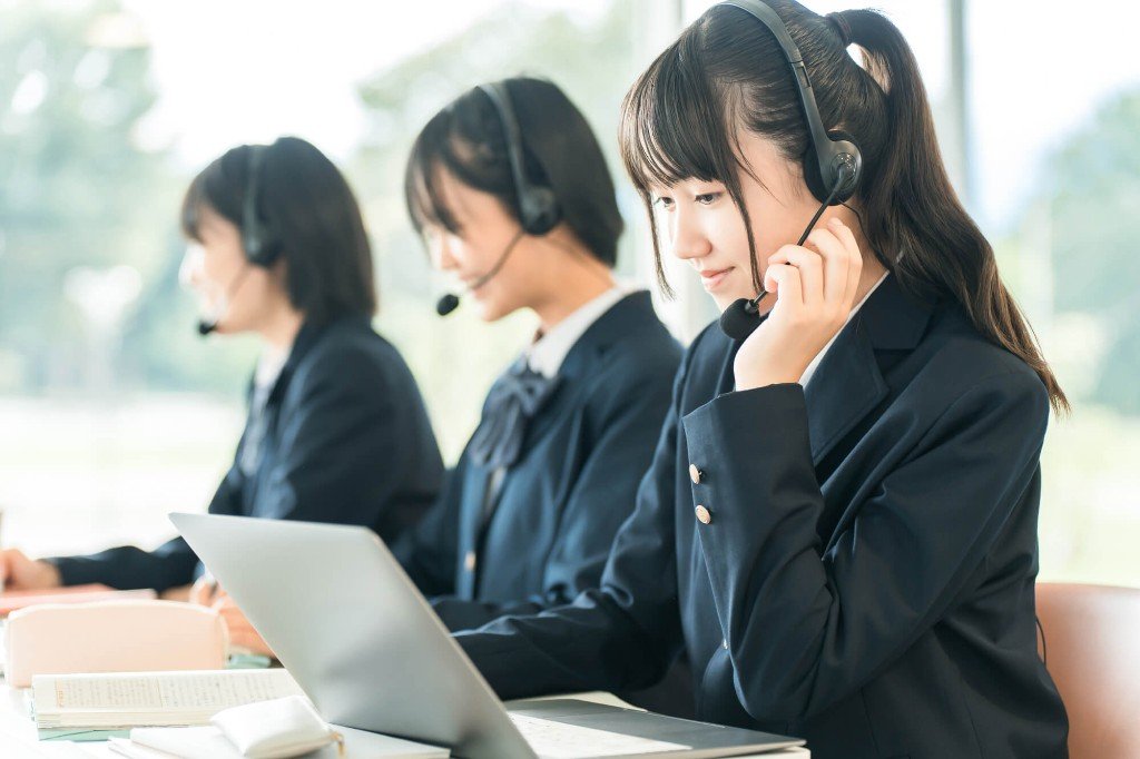 ヘッドセットを着け、パソコンで準1級のスピーキング練習をする学生