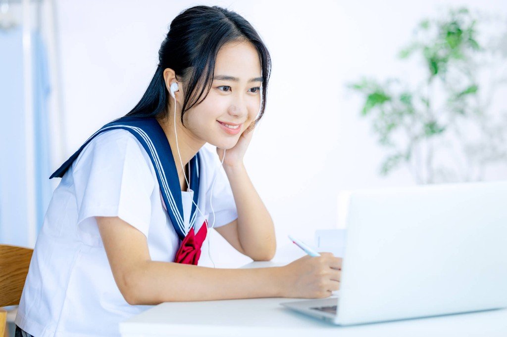 イヤホンを着け、ノートPCで学習する学生