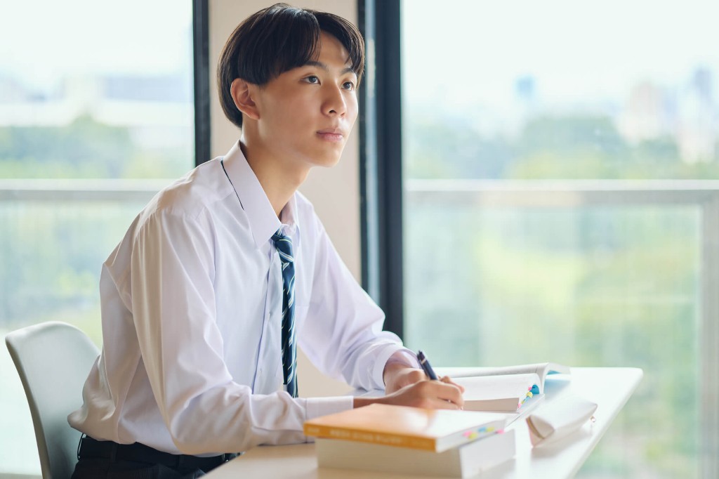 ノートを開き、次の学習を考える高校生