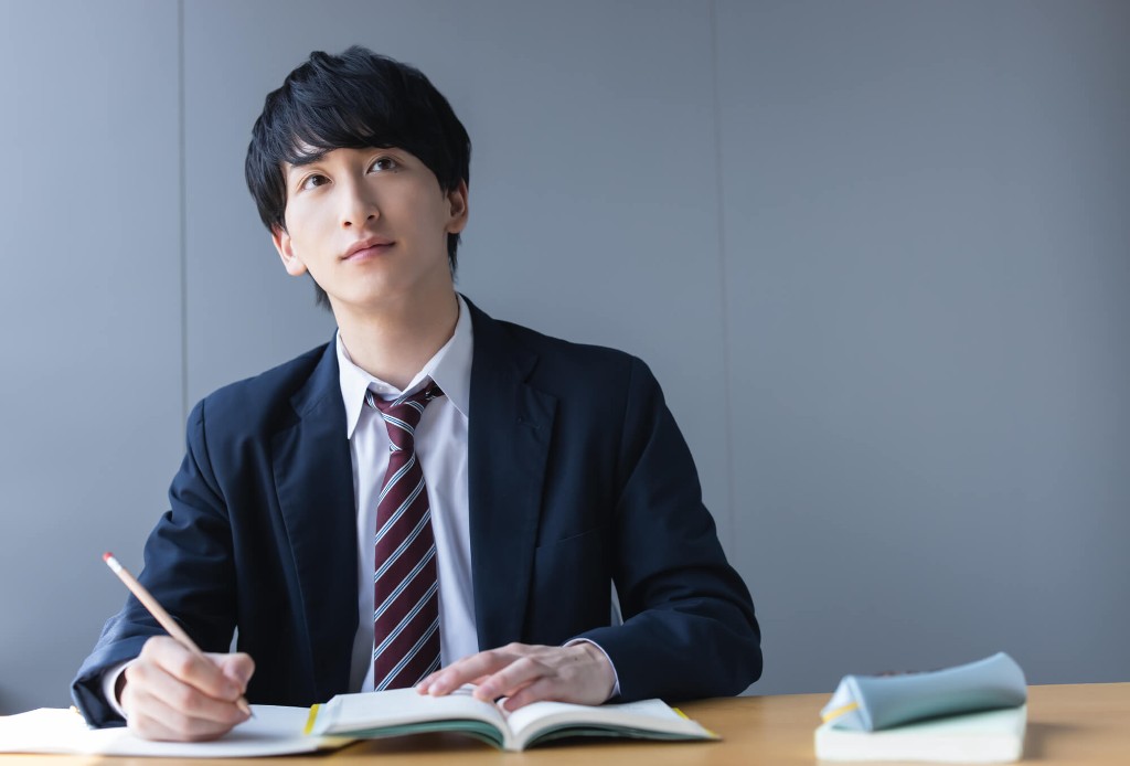 ノートを開き、準2級から次の級を考える高校生