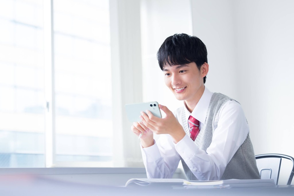 スマホでスキマ学習をする高校生