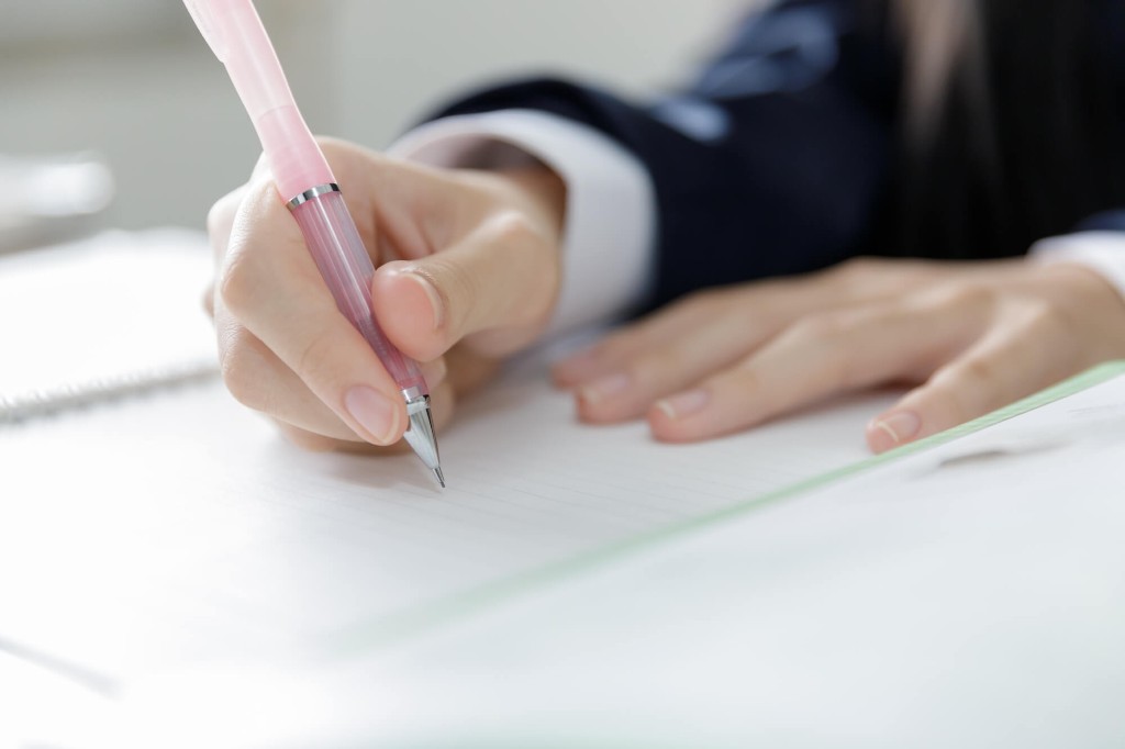 ノートにペンで書き進める手元