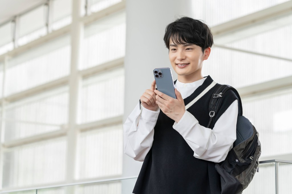 通学中にスマホで学習する高校生
