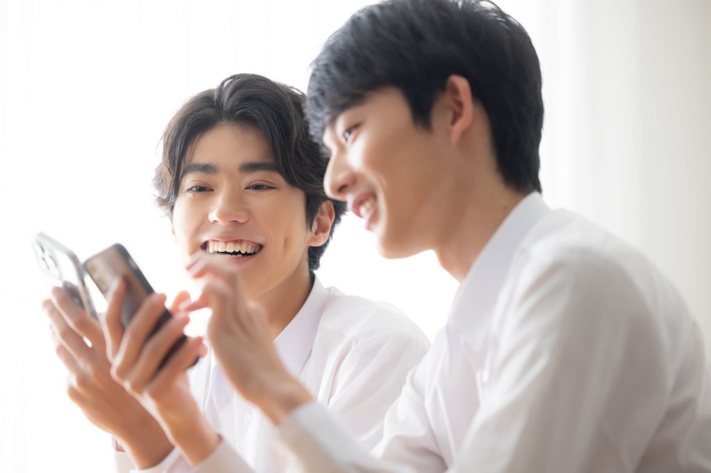 スマホを一緒に見て笑う二人